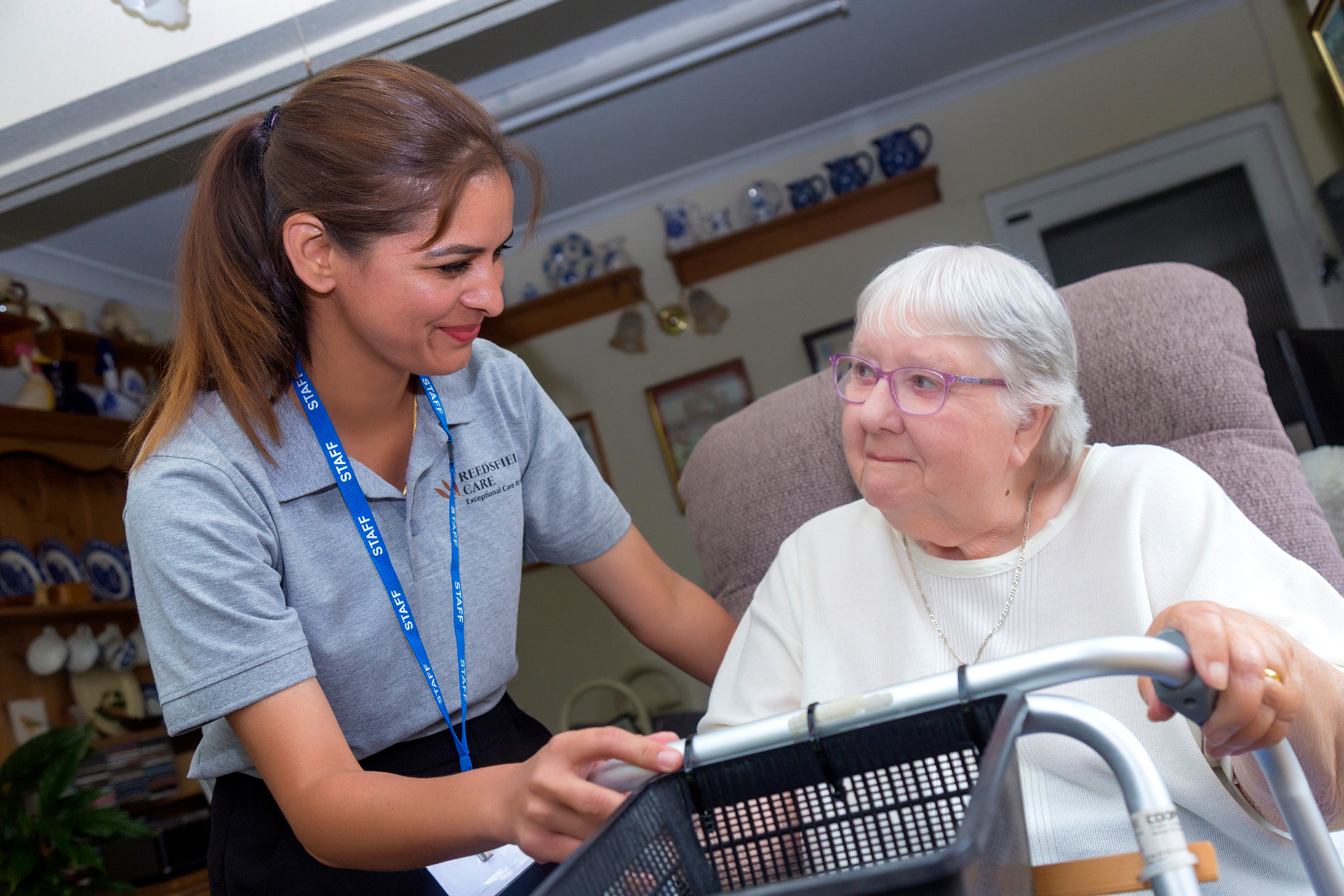 Reedsfield carer holding a client's hand at home in Egham, Surrey